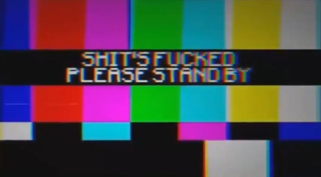A vintage television test pattern with colorful vertical bars and blocks, overlaid with the text 'SHIT'S FUCKED PLEASE STAND…