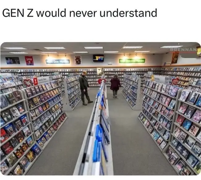 An image of a video rental store aisle filled with DVD cases, with two people browsing. The text overlaid at the top reads…