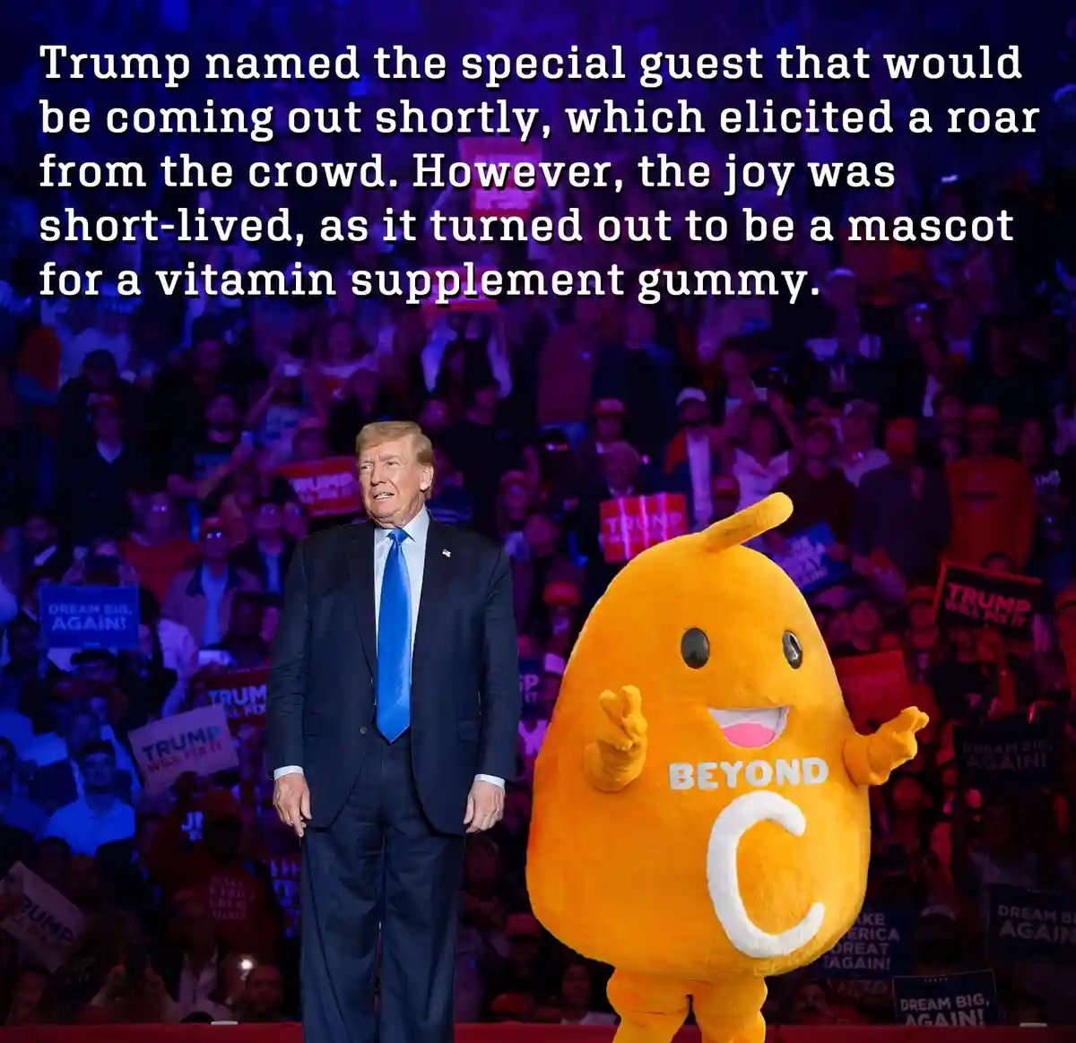 A man in a dark suit and blue tie stands on a stage in front of a crowd holding 'TRUMP WILL FIX IT' and 'DREAM BIG AGAIN!'…