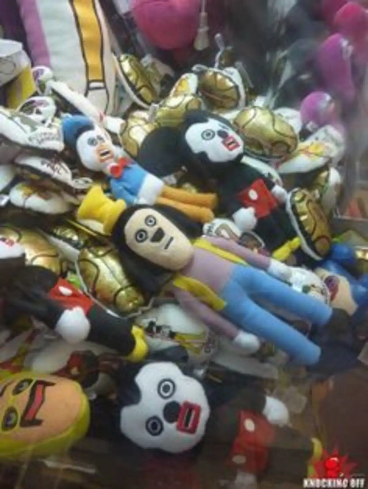 A pile of cheap, poorly made plush toys, including distorted Mickey Mouse and Donald Duck figures, are crammed together in a…