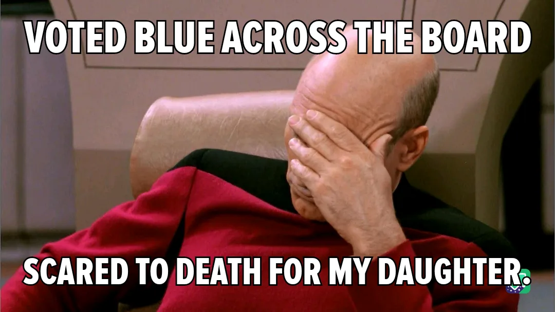 A bald man in a red uniform sits in a chair, covering his face with his hand in a gesture of despair or embarrassment. The…