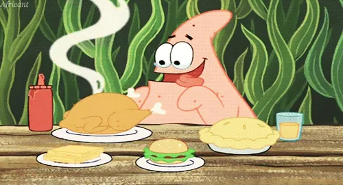 The image shows Patrick Star from SpongeBob SquarePants sitting at a wooden table with plates of food, including a turkey, a…