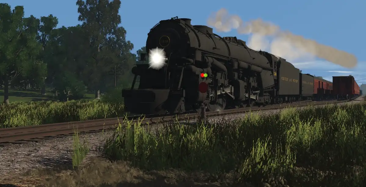A black steam locomotive with the number 1818 on its front is shown approaching on a railway track through a grassy field…