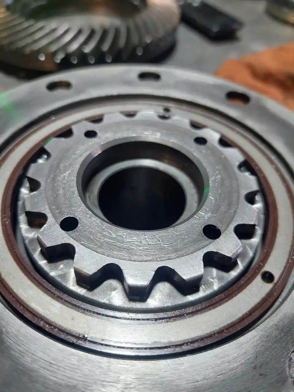 A close-up photo of a metallic mechanical gear with visible wear and a central hole, overlaid with the text 'i'm not a gear…