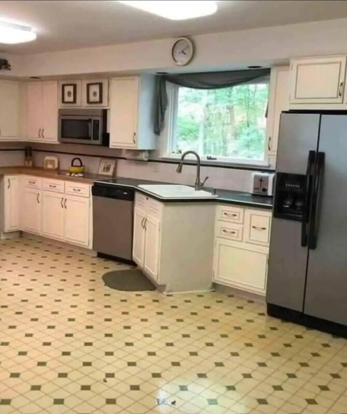 A photo of a kitchen with white cabinets, stainless steel appliances, and a patterned tile floor, overlaid with the text…
