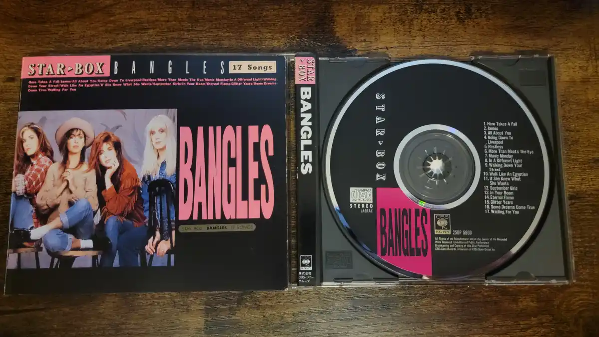 A physical CD case for the band Bangles' 'Star Box' compilation, open to show the cover art featuring four women and the CD…