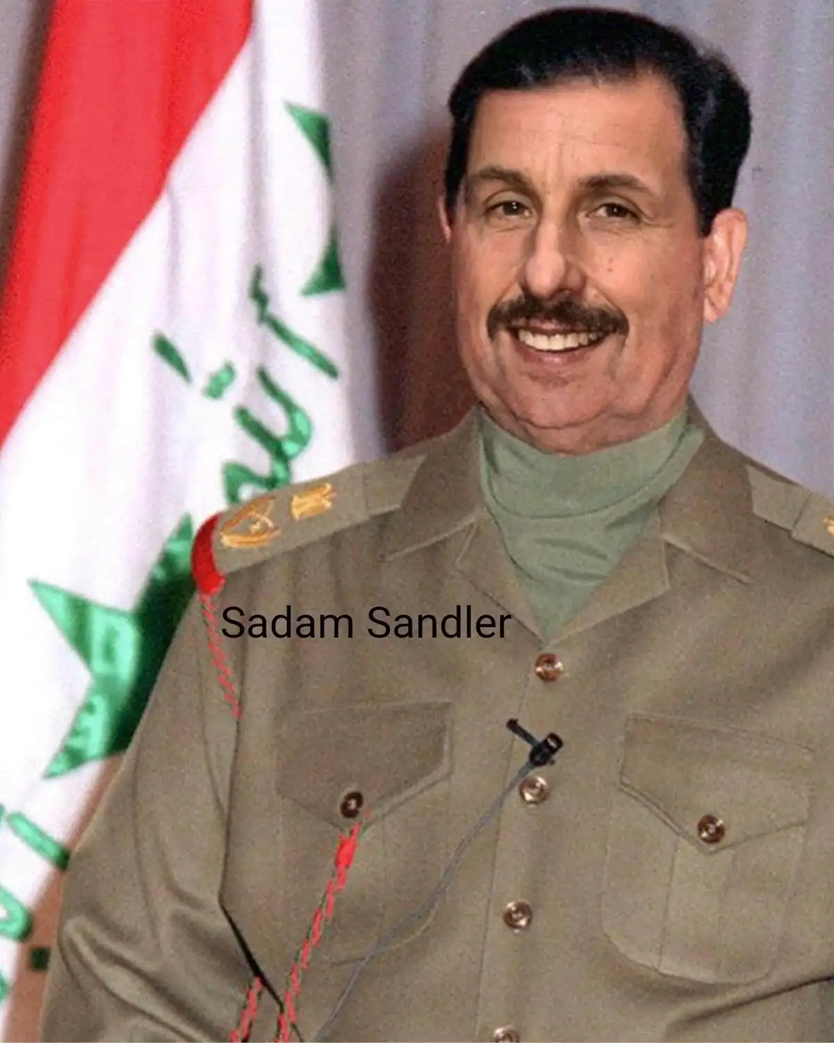 A man in a military uniform with a green turtleneck smiles in front of an Iraqi flag. The text 'Sadam Sandler' is overlaid…