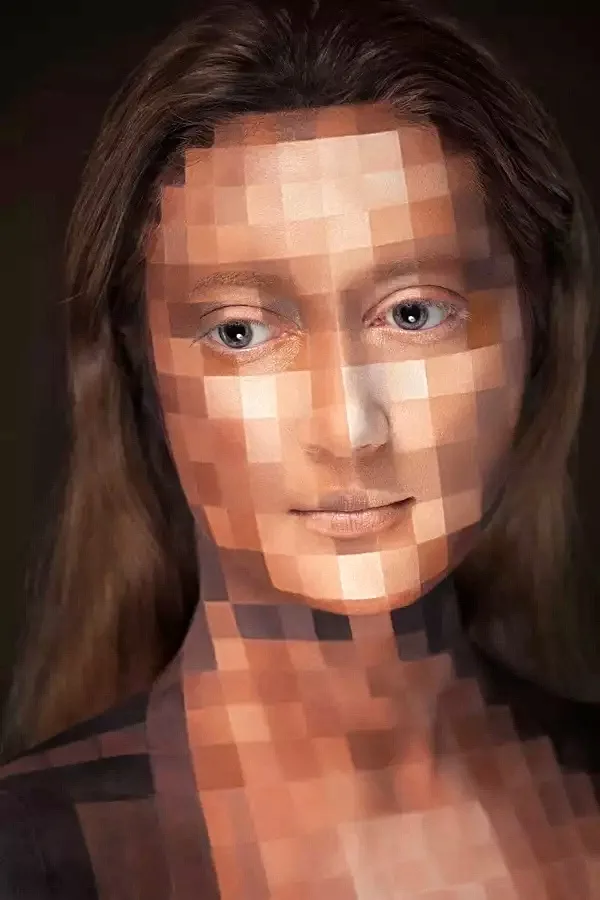A woman with brown hair and blue eyes has her face and upper torso heavily pixelated with square blocks, obscuring her…