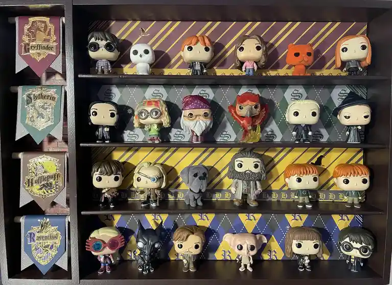 A dark wooden display case holds four shelves of Funko Pop! figures from the Harry Potter universe, each shelf backed by…
