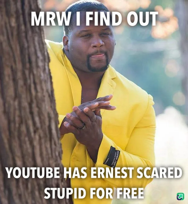 A man in a bright yellow suit peeks from behind a tree trunk with a smug, knowing expression. White bold text overlays the…