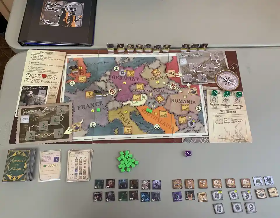 A top-down photo of the board game 'Shadows over Europe 1920' set up on a table, showing a detailed map of Europe with…