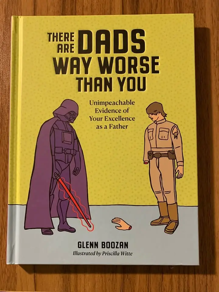 A book cover with a yellow background shows Darth Vader standing over a severed hand, while Luke Skywalker stands nearby…