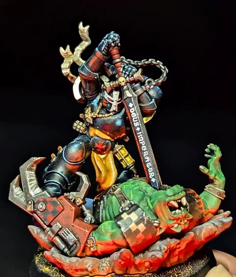 A painted miniature of a heavily armored, grim-faced warrior in dark armor with red and gold accents, standing triumphantly…