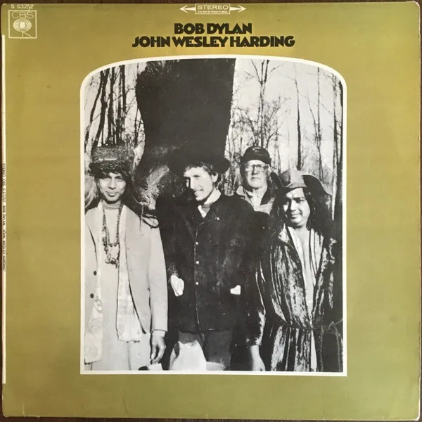 A vintage album cover for Bob Dylan's 'John Wesley Harding' shows four men in rustic, 1960s-style clothing standing outdoors…