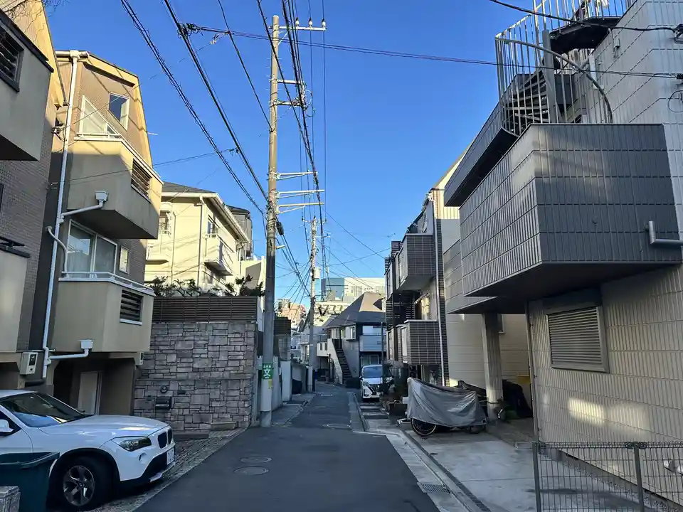 this is a photo of a narrow residential alleyway in japan with modern apartment buildings on both sides, a white bmw x1…