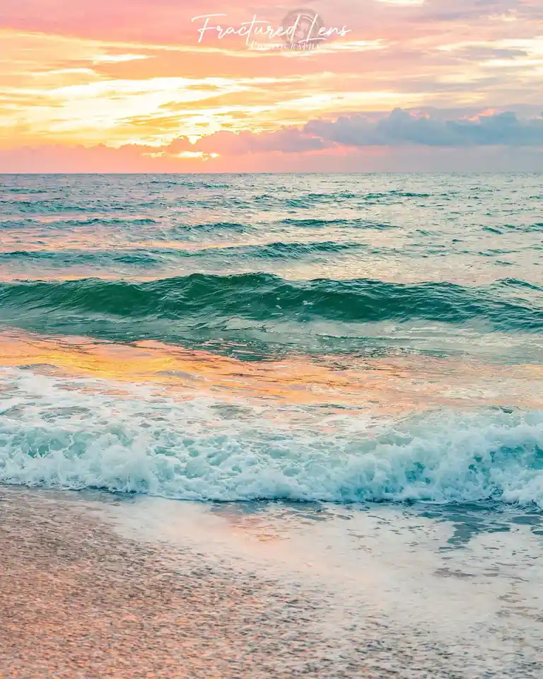 A serene beach sunset photo shows gentle ocean waves rolling onto a sandy shore under a sky painted with pink, orange, and…