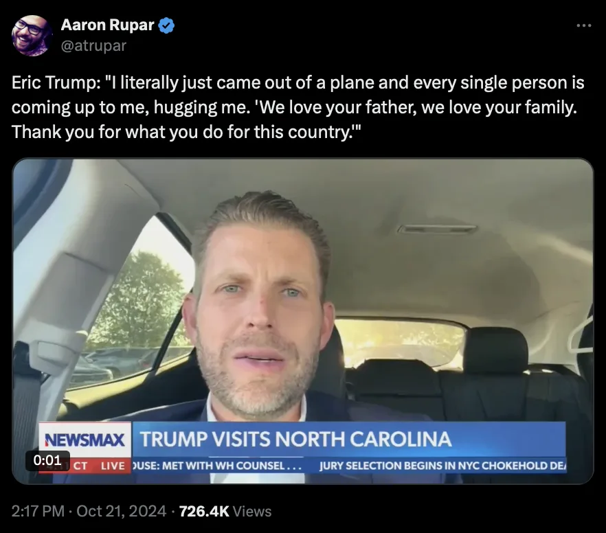 A screenshot of a Newsmax news segment showing Eric Trump sitting in a car, looking directly at the camera. The overlaid…
