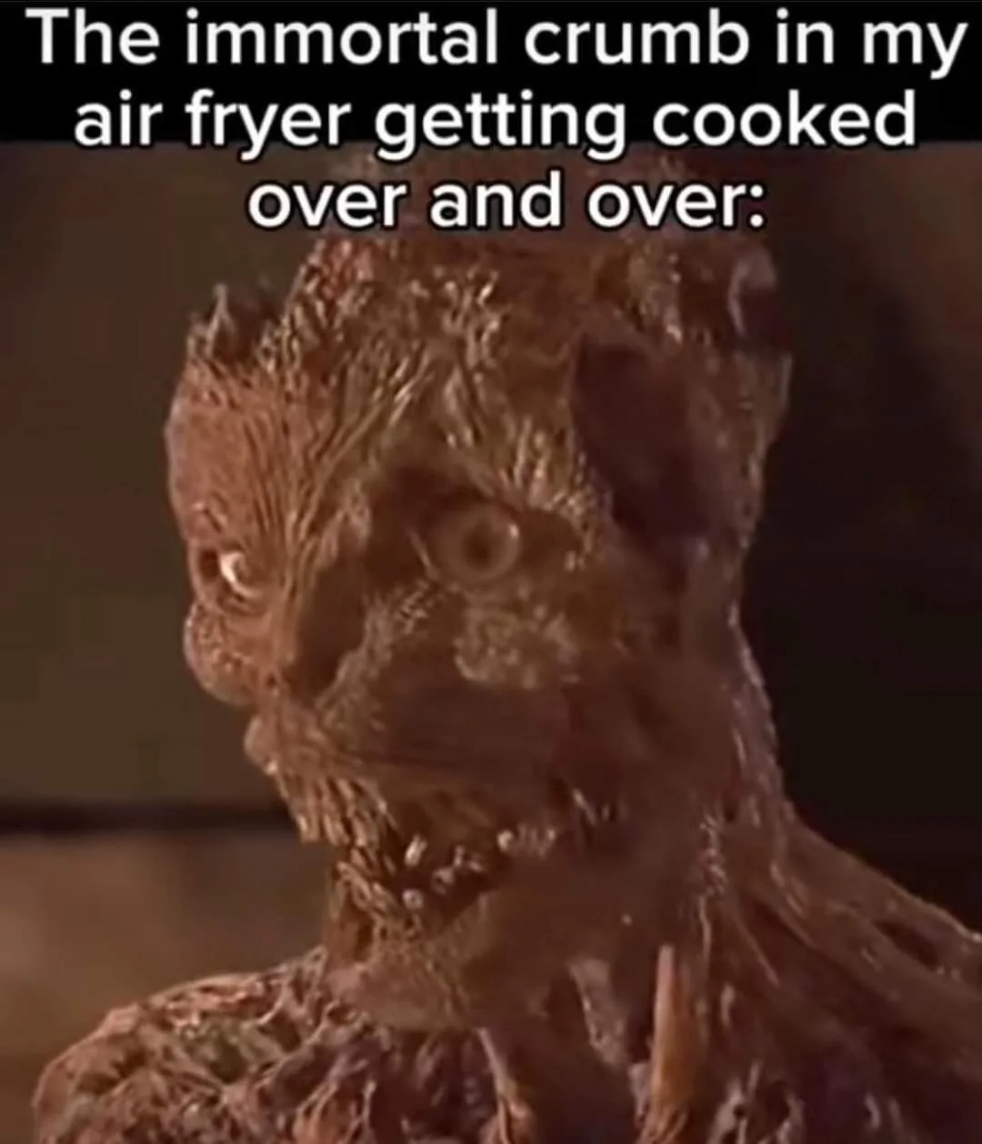 A close-up image shows a grotesque, textured, brownish creature with wide, terrified eyes and a distorted, wrinkled face…