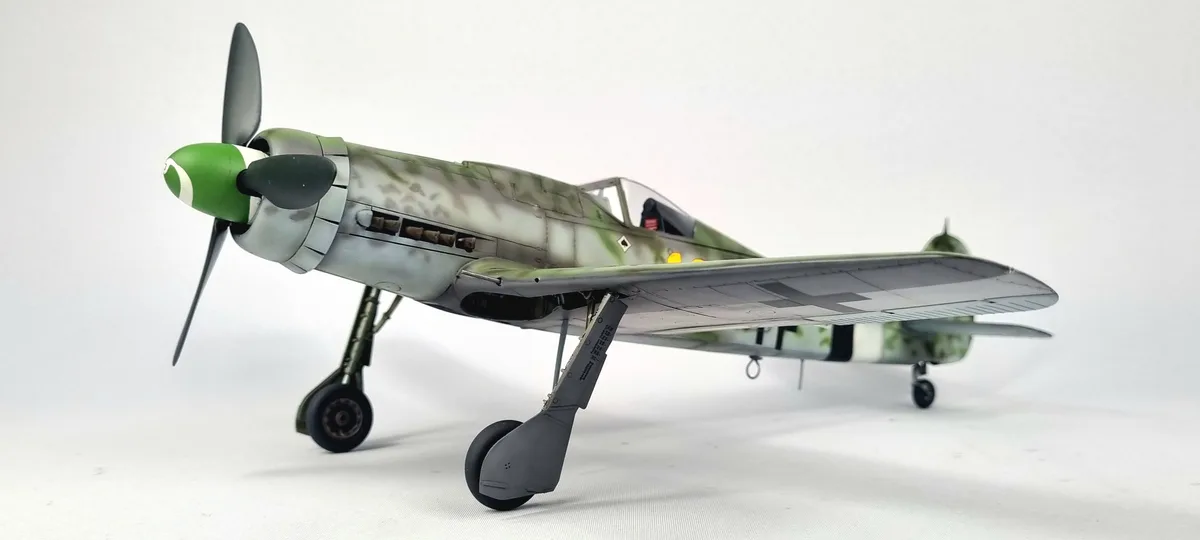 A detailed scale model of a World War II-era German fighter plane, likely a Messerschmitt Bf 109, is shown in profile…