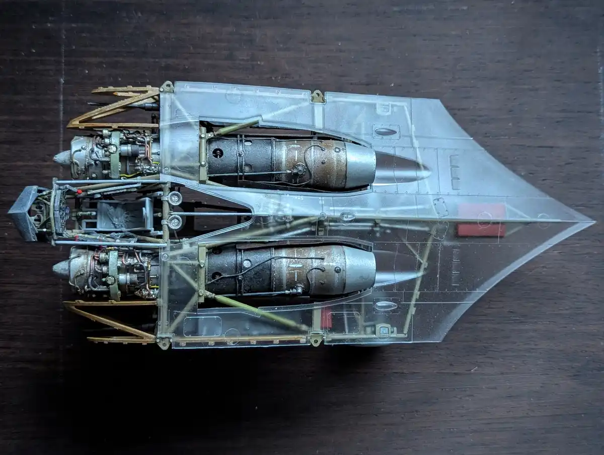 A highly detailed, transparent-hulled model of a futuristic jet fighter with exposed internal engines and wiring, resting on…