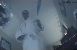 A man in a white robe and glasses is shown in six sequential frames, starting by holding a small white cat, then using a…