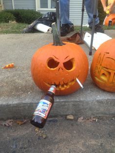 A carved jack-o'-lantern with a menacing face and a cigarette sticking out of its mouth, with a beer bottle lying on the…