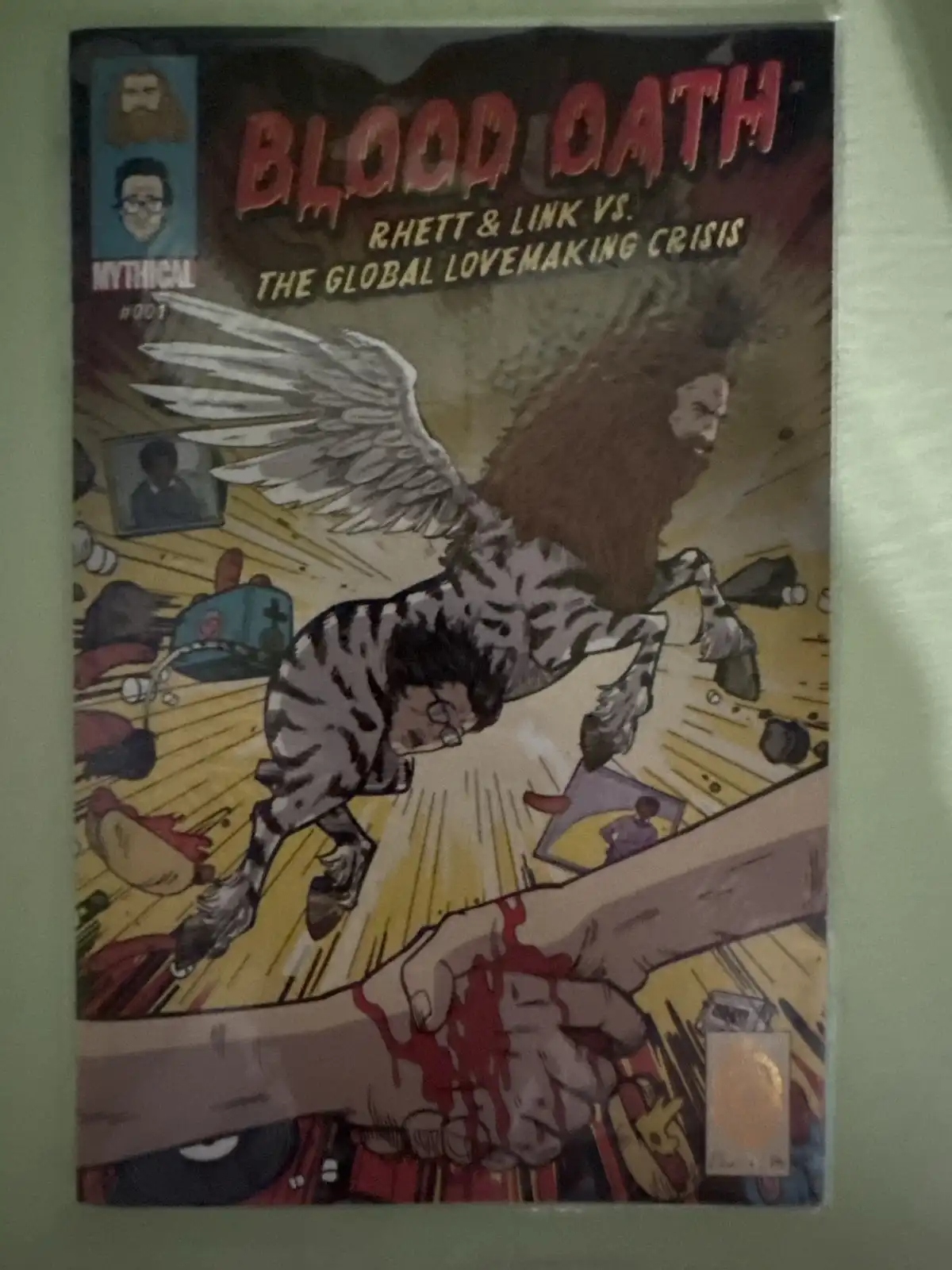 A comic book cover titled 'Blood Oath: Rhett & Link vs. The Global Lovemaking Crisis' depicts a winged, zebra-striped…