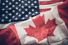 Two national flags, the United States flag and the Canadian flag, are visibly crumpled and overlapping in the image. The…