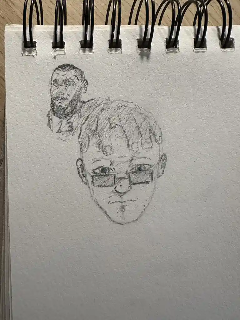 A pencil sketch on a spiral-bound notebook page shows a detailed drawing of a man with glasses in the foreground and a…