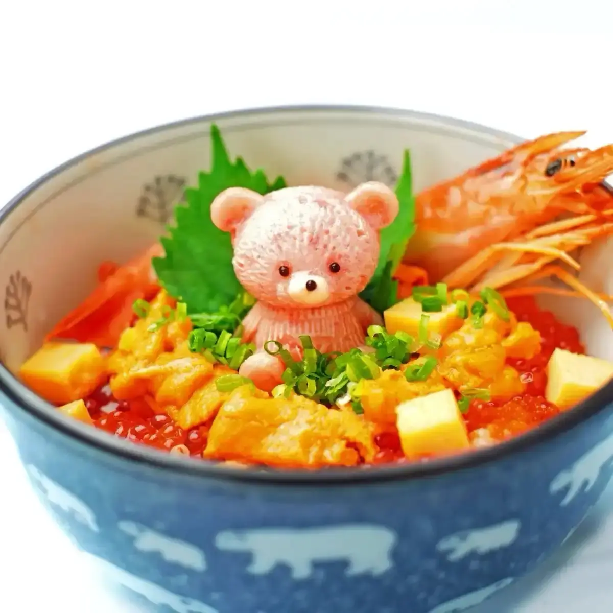 A close-up of a colorful Japanese donburi bowl filled with rice, shrimp, orange fish roe, green onions, and cubes of tofu…