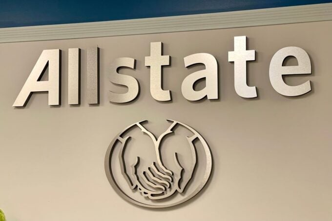 A close-up photo of the Allstate corporate logo, featuring the word 'Allstate' in large, silver, 3D letters mounted on a…