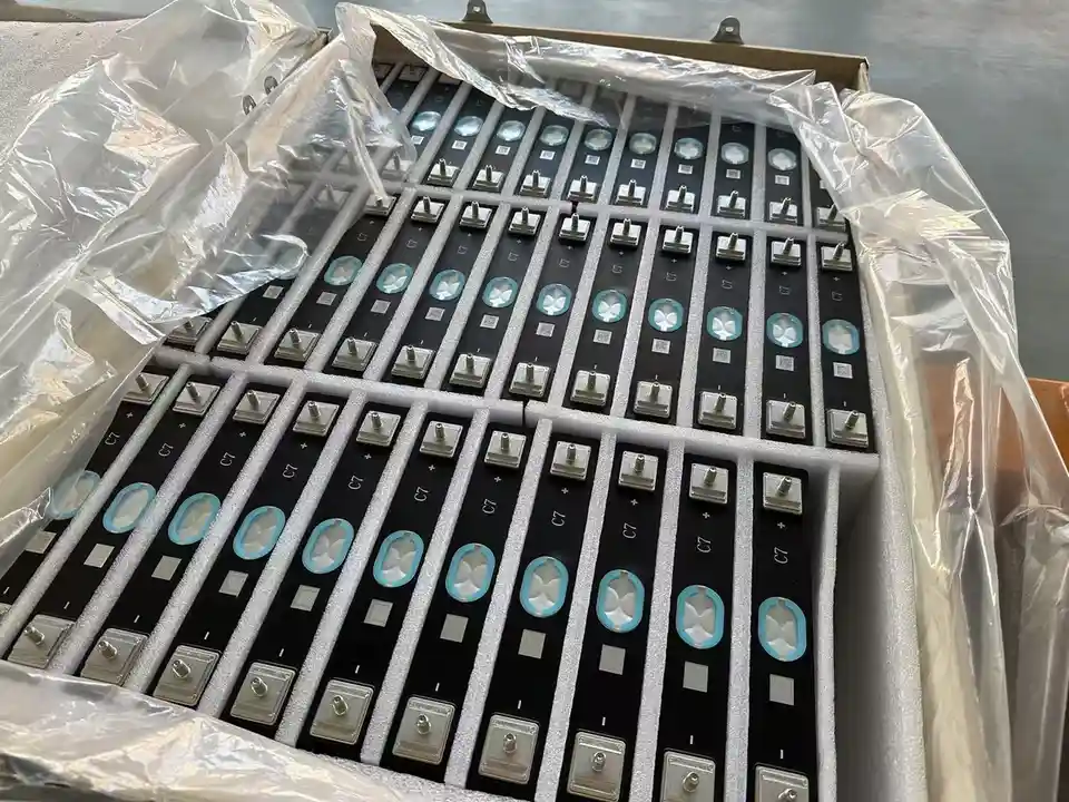 A box filled with numerous identical black keyboard keycaps, each with a silver stem and a blue-tinted circular window…