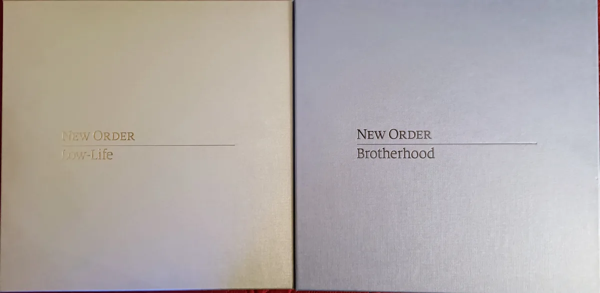 Two album covers side by side, one beige with 'NEW ORDER Low-Life' and one silver with 'NEW ORDER Brotherhood', both…