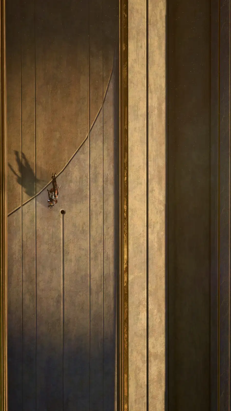 A small, detailed figurine of a person is shown hanging upside down from the top edge of a tall, vertically paneled wooden…