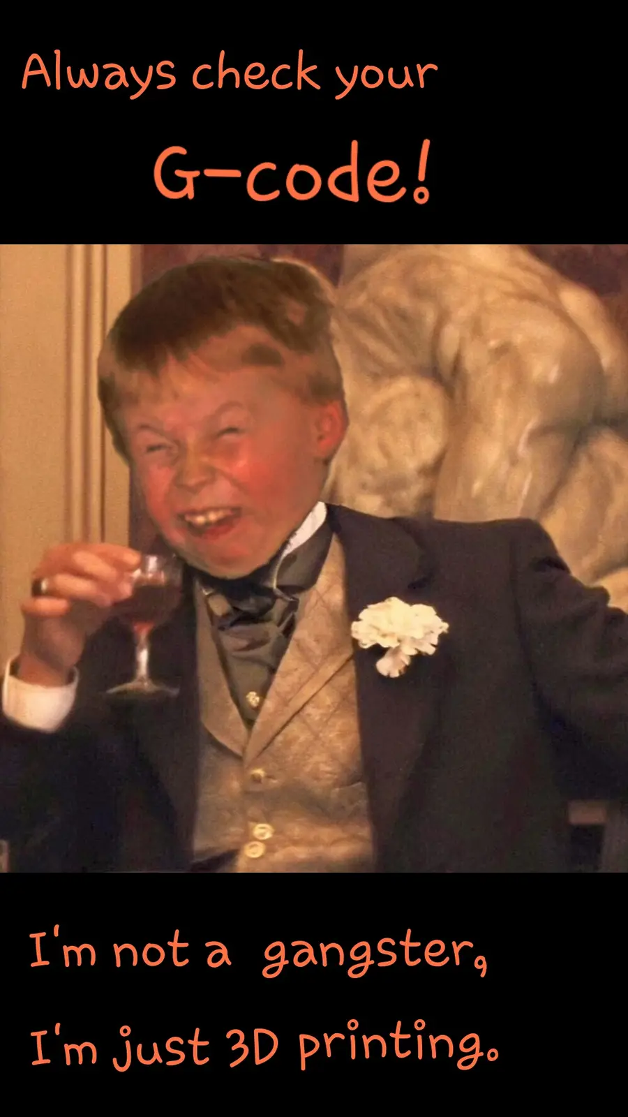 A young boy in a formal suit with a white flower boutonniere holds a glass of red liquid while grinning widely. The image…