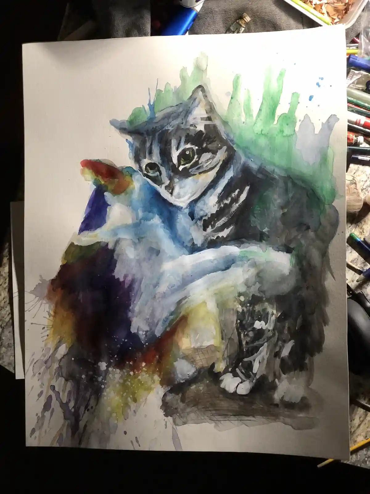 A watercolor painting of a tabby cat sitting upright, rendered with expressive brushstrokes and vibrant, splattered colors…