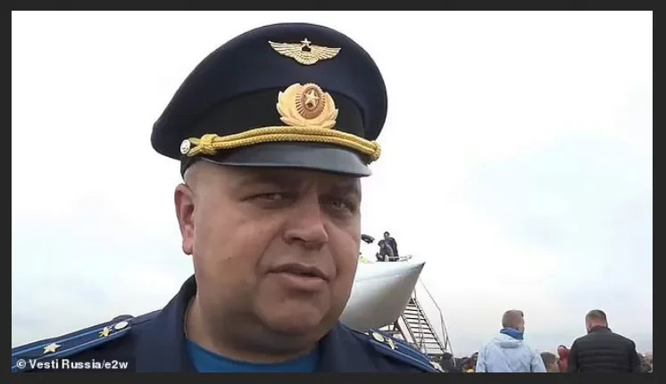 A man in a Russian military pilot uniform with gold epaulets and insignia looks directly at the camera with a serious…