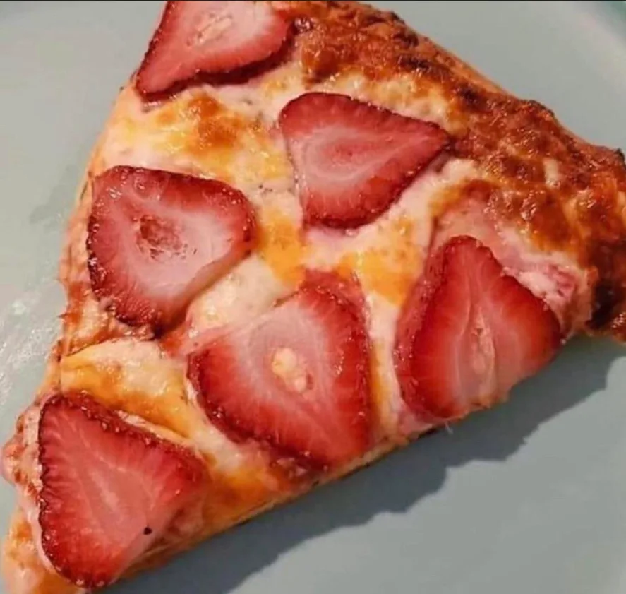 A close-up photo shows a single slice of pizza on a light-colored plate, topped with melted cheese and numerous sliced…