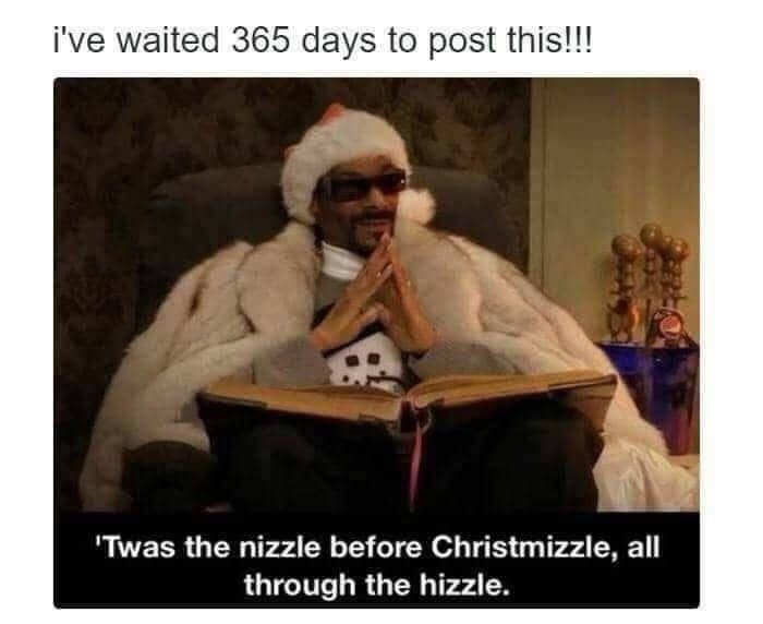 A man wearing a Santa hat and sunglasses sits in a chair draped in a white fur coat, hands clasped in prayer while holding…