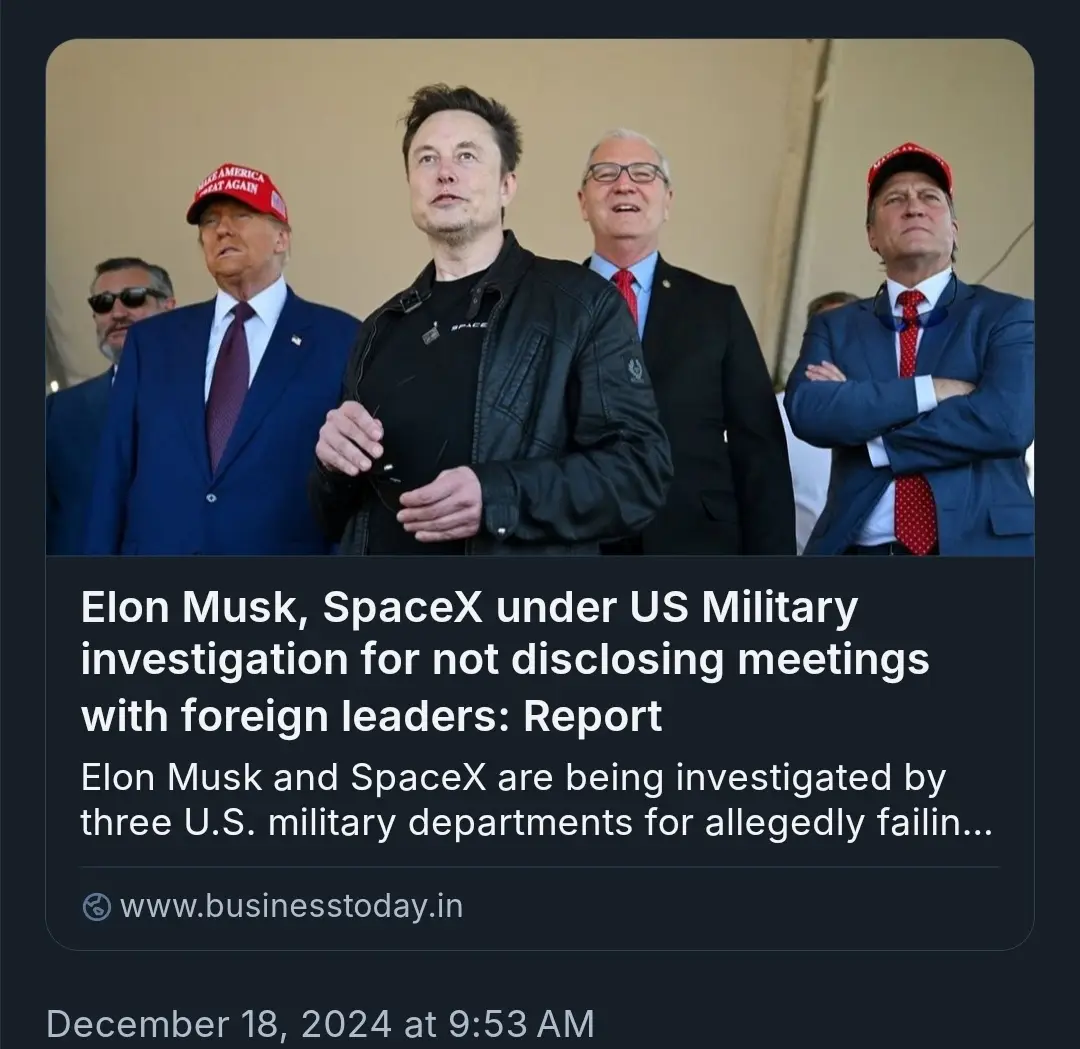 A photo shows Elon Musk in a black jacket standing among several men in suits, some wearing red 'Make America Great Again'…
