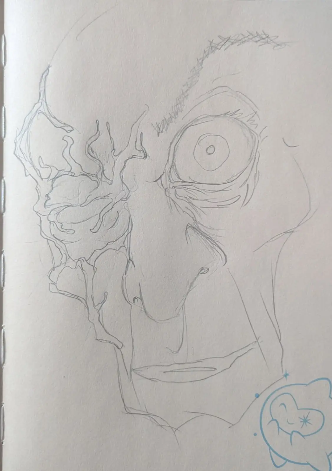 A rough pencil sketch on paper shows a distorted, melting face with one eye and a stitched eyebrow, while a small blue…