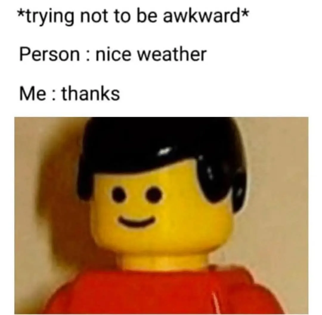 A close-up of a yellow Lego minifigure with black hair and a red torso, smiling slightly. The image has overlaid text…