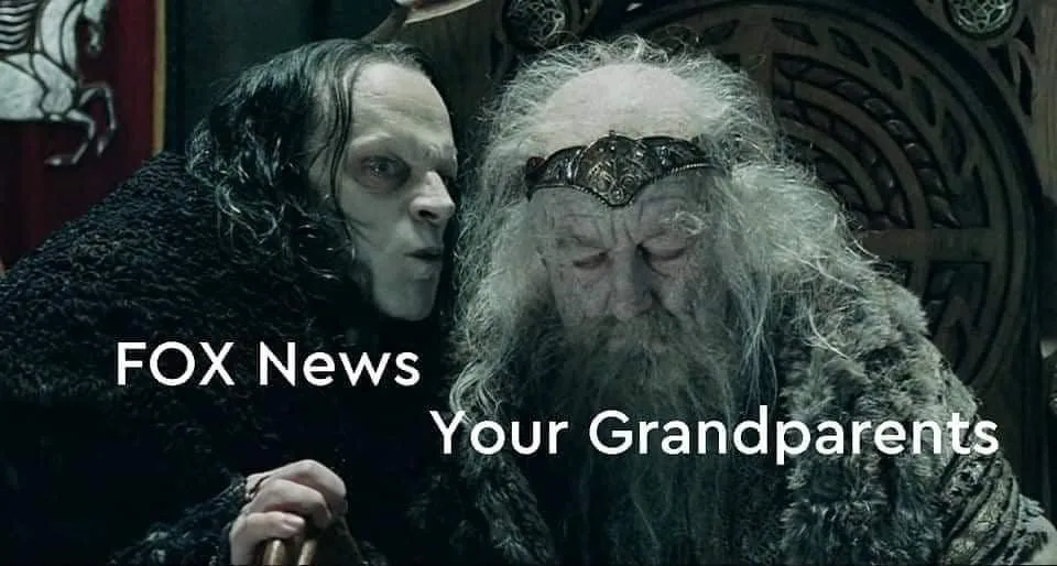 A still from a fantasy movie shows a pale, menacing figure whispering into the ear of an elderly, bearded man seated on a…