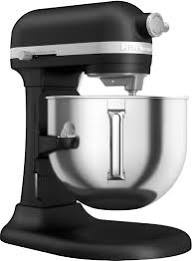 A black KitchenAid stand mixer with a stainless steel mixing bowl is shown against a white background. Overlaid text reads…