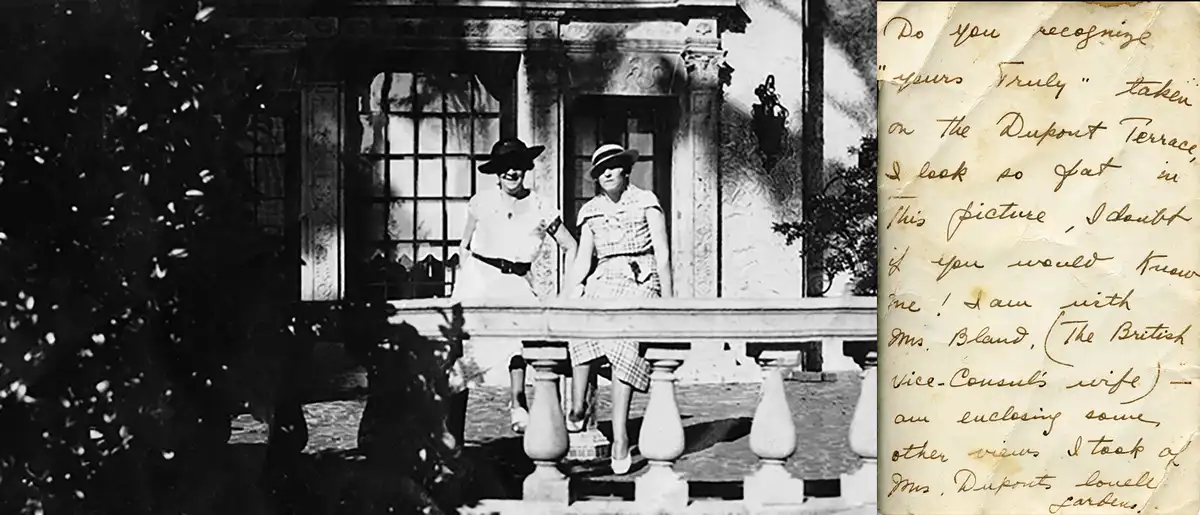 A vintage black-and-white photo shows two women in 1920s attire sitting on a stone balcony of an ornate building, with…