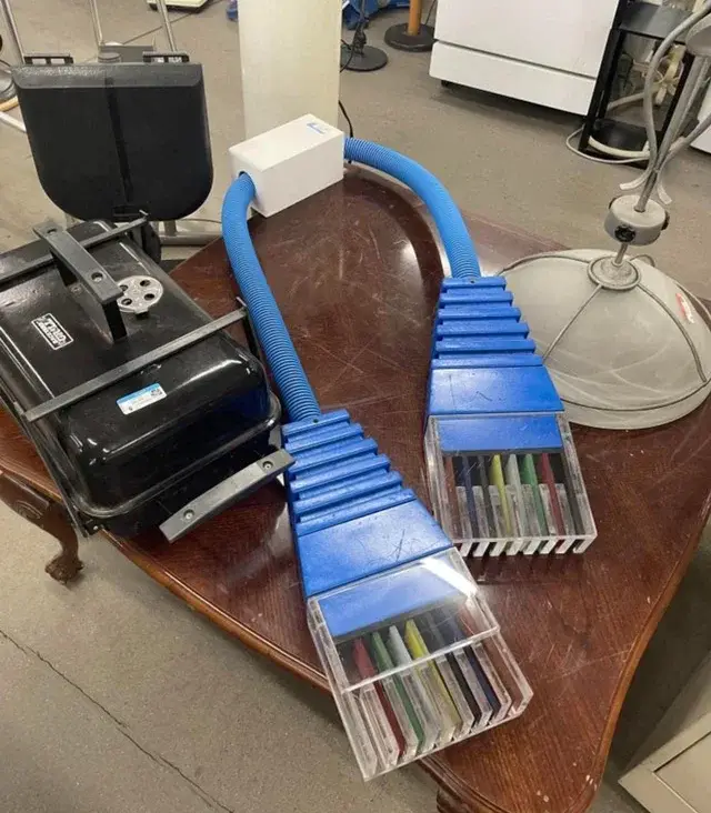 A photo shows two giant blue ethernet cables with clear plastic ends revealing colorful crayons inside, plugged into a white…