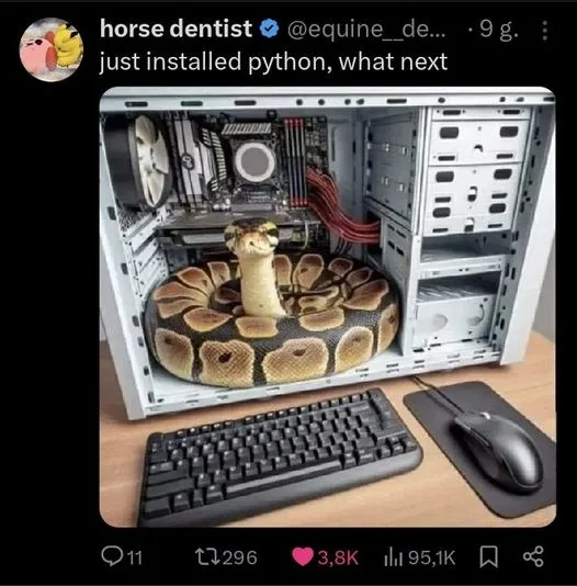 An open computer case with a large snake coiled around the motherboard and CPU, with a keyboard and mouse in front. The…