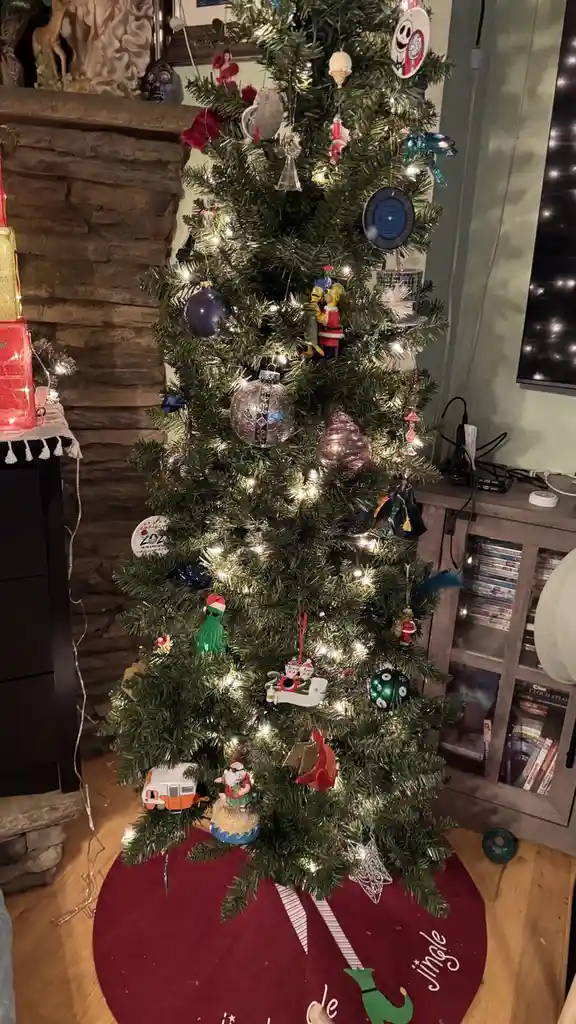 a decorated christmas tree with numerous ornaments, including simpsons figures, a green octopus, and a 2020 covid-19…
