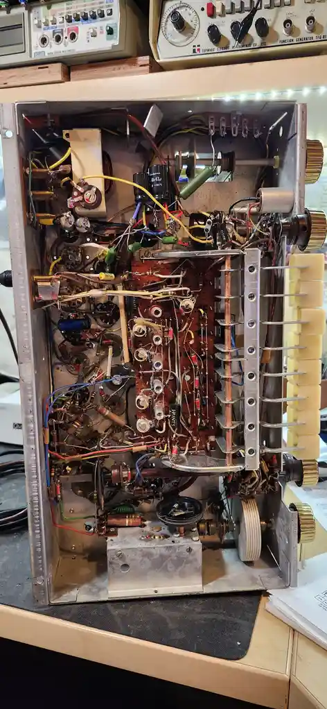 The image shows the open, densely packed interior of an old electronic device, revealing a chaotic tangle of wires…