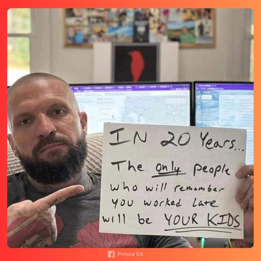 A man with a beard and tattoos holds a handwritten sign that reads 'IN 20 Years... The only people who will remember you…